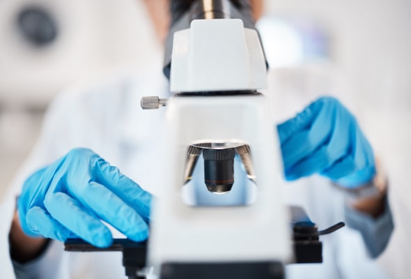 Photo of a person looking through a microscope